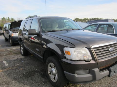 1991 Ford LTD Crown Victoria - A dark gray Ford Explorer SUV is parked in a lot, with another vehicle behind it.