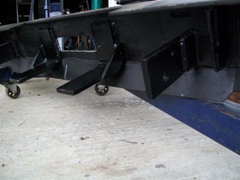 1982 Ford F-100 - Custom bumper fabrication with visible metal brackets and caster wheels on a concrete floor.