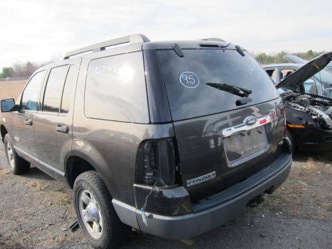 1991 Ford LTD Crown Victoria - Rear view of a dark gray Ford Explorer SUV in a junkyard, with a second vehicle visible in the background.