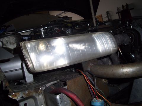 1995 Ford Probe - Close-up view of a vehicle's headlight assembly, showing engine components and wiring in the background.