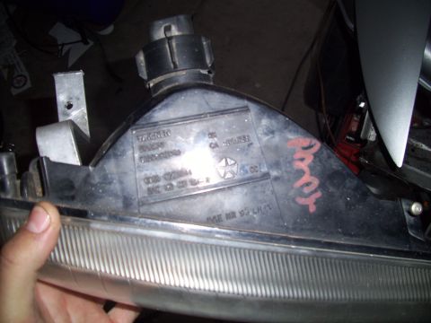1995 Ford Probe - Car headlight assembly showing manufacturer markings and part numbers.