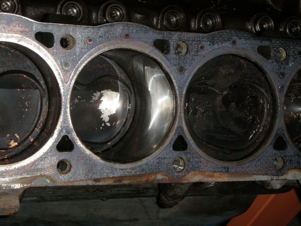 Engine block with four cylinders and pistons visible