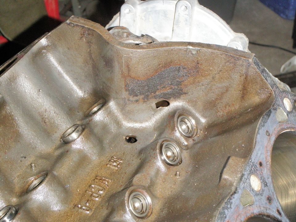Close-up of a rusty engine block with visible casting marks and bearing surfaces
