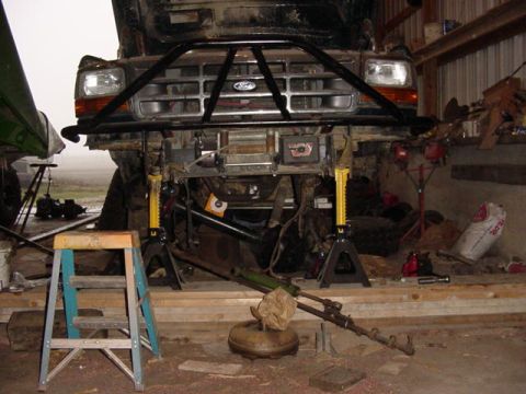 1992 Ford Bronco - Front end of a 1992 Ford Bronco undergoing work, a custom bull bar and various tools.
