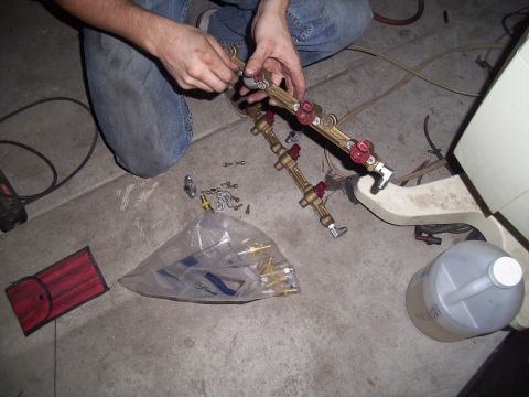 1995 Ford Probe - Assembling a fuel rail system with various fittings and parts laid out on a concrete floor.