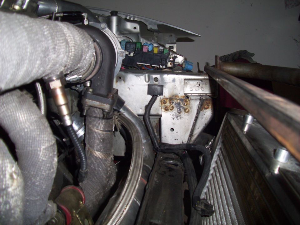 Engine bay with turbocharger, exhaust manifold, and fuse box. Some rust is visible