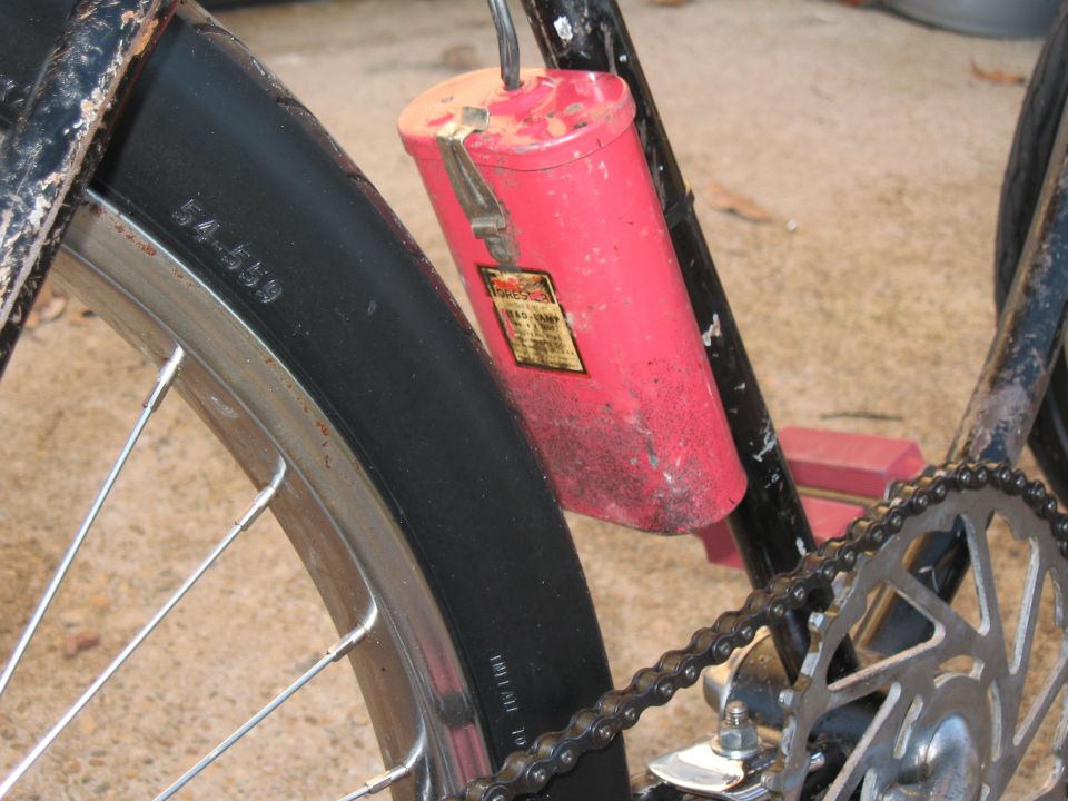 bicycle tire with 54-559 marking and red cylindrical component with yellow label