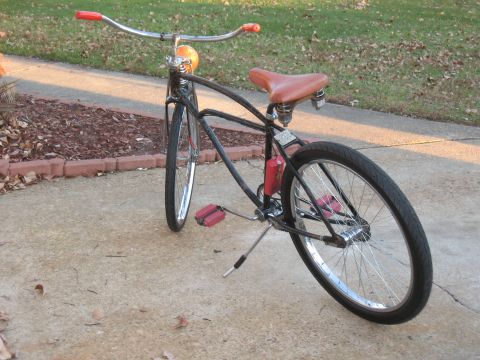 1994 Ford Bronco - A custom cruiser bicycle is parked on a concrete path next to a lawn.