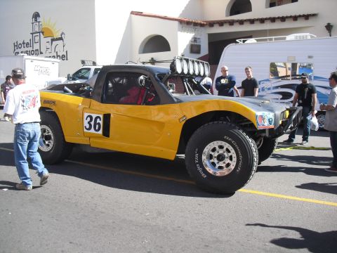 1986 Ford Bronco - A custom-built off-road truck with racing modifications is parked on a street.