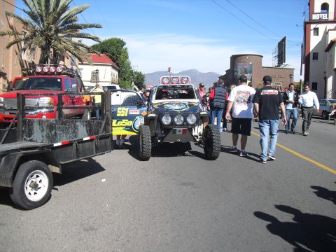 1986 Ford Bronco - Off-road buggy with multiple lights and racing decals parked on a street.