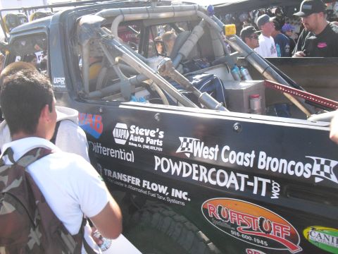 1986 Ford Bronco - A custom off-road truck with numerous sponsor decals is seen up close during an event.