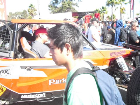 1986 Ford Bronco - An off-road buggy is seen with branding and people in the background.