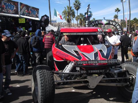 1986 Ford Bronco - A custom off-road buggy is displayed at an event, with spectators gathered around.