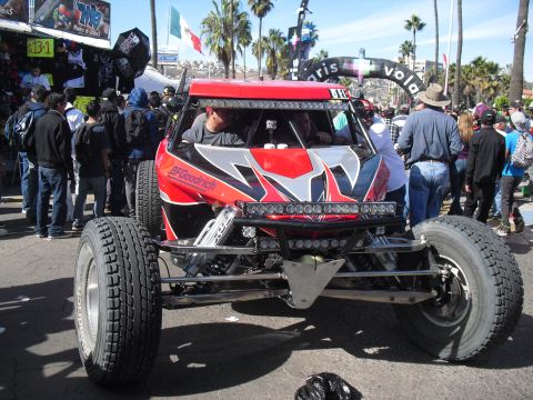 1986 Ford Bronco - A custom off-road buggy with BFGoodrich tires and numerous light bars is seen at an event, possibly the Baja 1000.