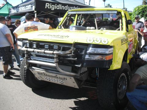 1986 Ford Bronco - Modified truck with extensive roll cage and light bars, likely for desert racing.