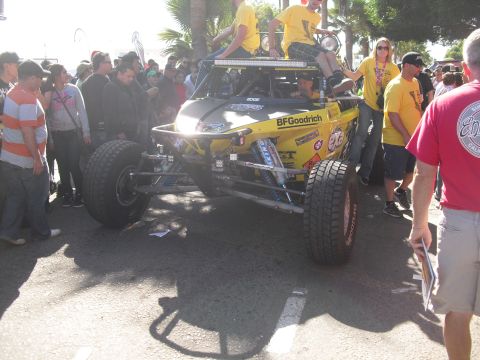 1986 Ford Bronco - A yellow off-road racing buggy with BFGoodrich tires and a light bar is surrounded by spectators.