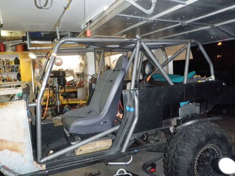 1961 International Scout 800 - A custom roll cage and racing seat are visible in a vehicle undergoing modification.