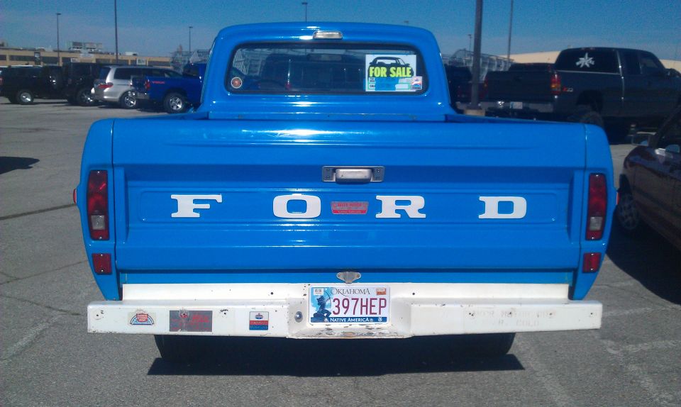 Rear view of blue 1973 Ford F-100 with 'FORD' tailgate lettering and Oklahoma license plate