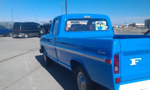 1973 Ford F-100 - Blue 1973 Ford F-100 pickup truck seen from the rear, parked outdoors with a for sale sticker.