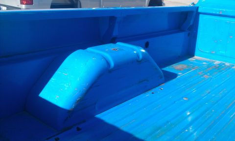 1973 Ford F-100 - Interior view of a blue truck bed with visible wheel wells and ribbed flooring.