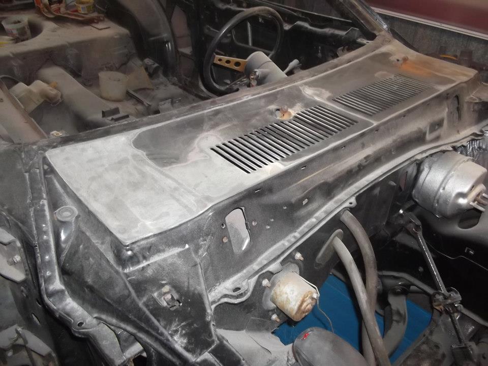 Car dashboard under repair, showing vents, steering column, and brake booster