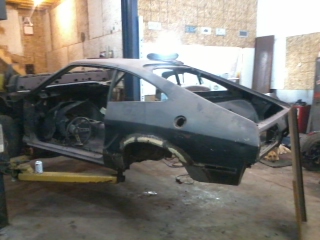 1978 Ford Mustang II - This car body is on a lift in a workshop, undergoing some work.