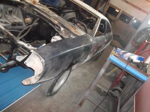 1978 Ford Mustang II - A 1978 Ford Mustang II is undergoing repairs in a garage, showing its disassembled front end.