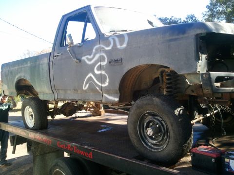1990 Ford Bronco - This Ford F-350 pickup truck is on a tow truck, appearing to be undergoing repairs or being transported.