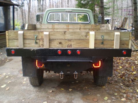1979 Ford Bronco - Rear view of a flatbed truck, likely from the late 1970s, with a custom wooden bed.