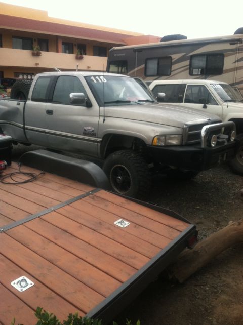 2004 Ford F-150 - A silver Dodge Ram pickup truck, likely from the mid-1990s, is parked outdoors with a trailer in the foreground.