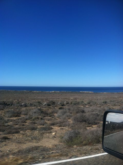 2004 Ford F-150 - View from a vehicle traveling through a dry, arid landscape towards the ocean.