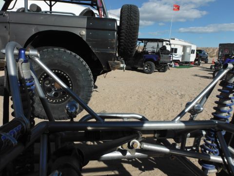 1979 Ford Bronco - Off-road buggy front end with a modified 1979 Ford Bronco in the background at a desert campsite.