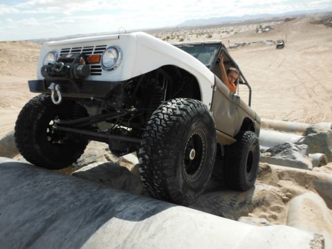 1979 Ford Bronco - This heavily modified Ford Bronco is navigating a rocky obstacle course in a desert environment.