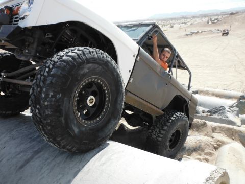 1979 Ford Bronco - Modified off-road vehicles navigate challenging terrain in a desert environment.