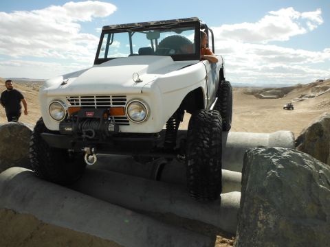 1979 Ford Bronco - This 1979 Ford Bronco navigates a challenging off-road obstacle course under a partly cloudy sky.
