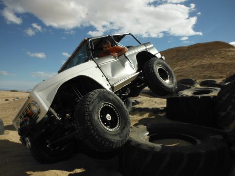 1979 Ford Bronco - A modified Ford Bronco navigates a challenging obstacle course in a sandy, desert environment.