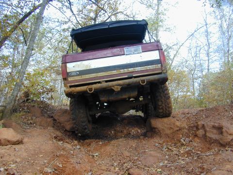 1996 Ford Bronco - This modified Ford Bronco navigates a challenging off-road course with a rooftop tent installed.