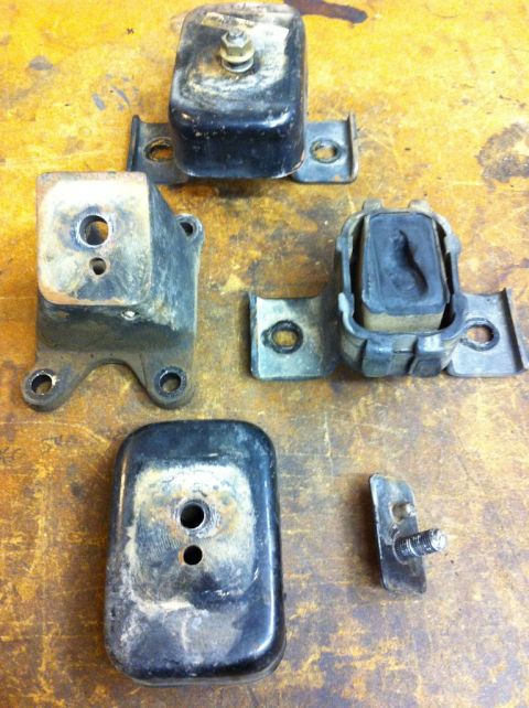 1987 Suzuki Samurai - Collection of engine mounts, some with rubber dampening, laid out on a workbench.