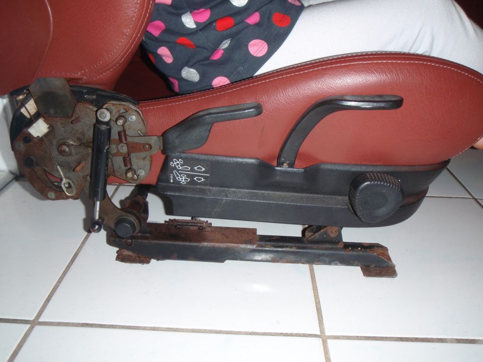 Car seat base with adjustment levers and rusty metal rails