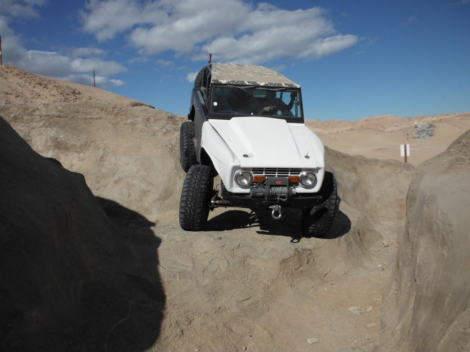 1979 Ford Bronco climbing a dirt hill with a winch on the front