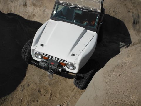 1979 Ford Bronco - White off-road SUV navigates a rocky terrain with a winch mounted on the front.