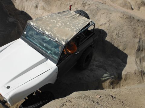1979 Ford Bronco - This 1979 Ford Bronco is shown off-roading in a sandy, rocky environment with a camouflage soft top.