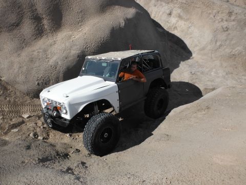 1979 Ford Bronco - A modified off-road vehicle navigates a rocky, desert terrain.