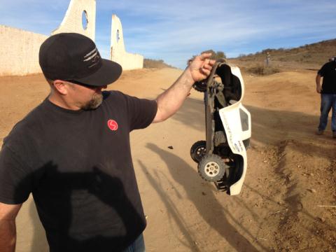 1986 Ford Bronco - Man holds a white remote control truck upside down outdoors.