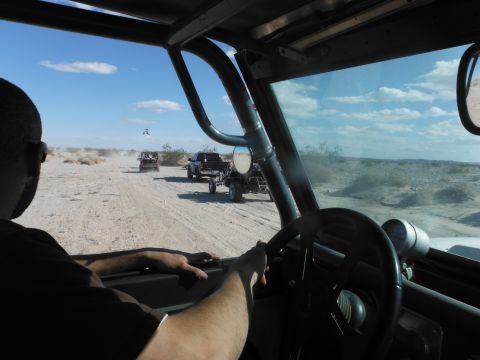 1979 Ford Bronco - Driving through a desert landscape with other off-road vehicles ahead.