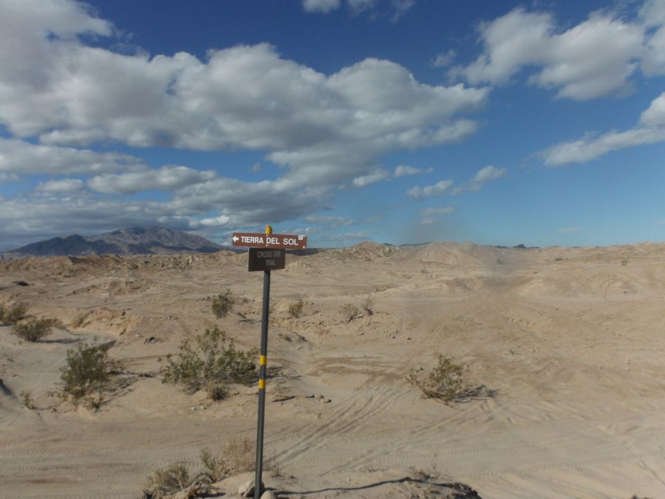 Desert landscape with a signpost pointing to Tierra Del Sol and Cross Up Trail