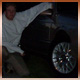 1993 Ford Taurus - A person is shown next to the wheel and fender of a dark-colored vehicle.