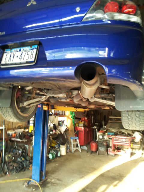 2006 Mitsubishi Evolution - The rear underside of a blue Mitsubishi Evolution is shown on a car lift in a garage setting.