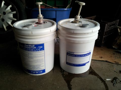 2006 Mitsubishi Evolution - Two industrial buckets with pumps are shown in a cluttered garage setting.