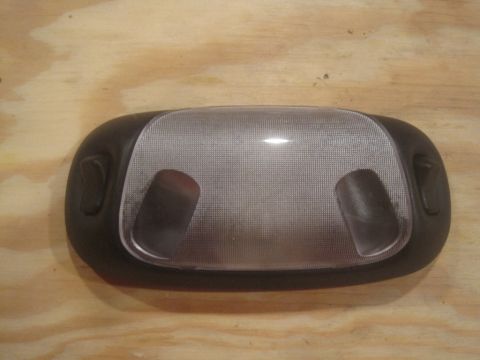 1993 Ford Bronco - This is a vehicle's interior dome light assembly, shown against a wooden background.